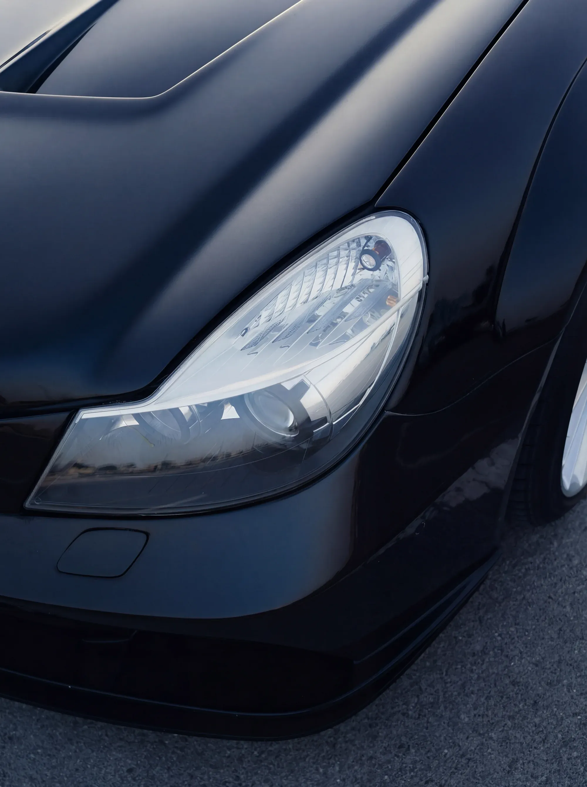 Silver Mercedes-Benz parked on a road, atmospheric lighting.