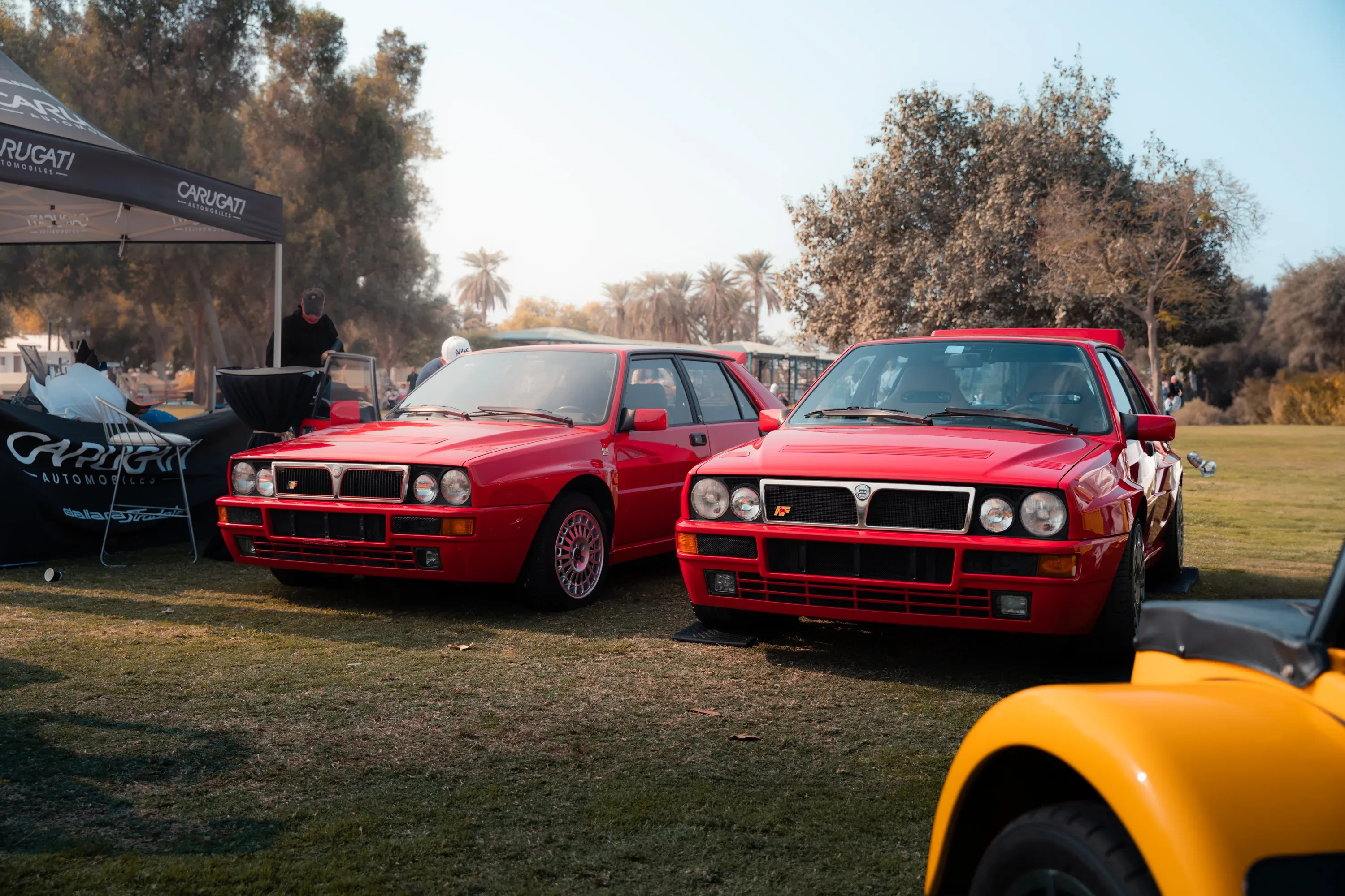 Crowd gathered around exotic cars at a high-end automotive event.